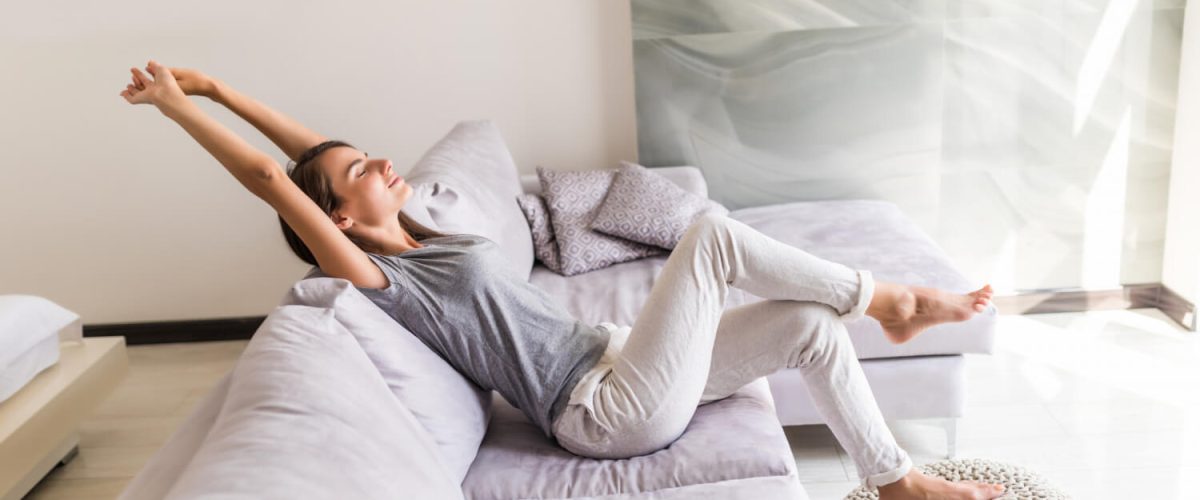 Smiling young woman relax lying couch staycation 1200x500