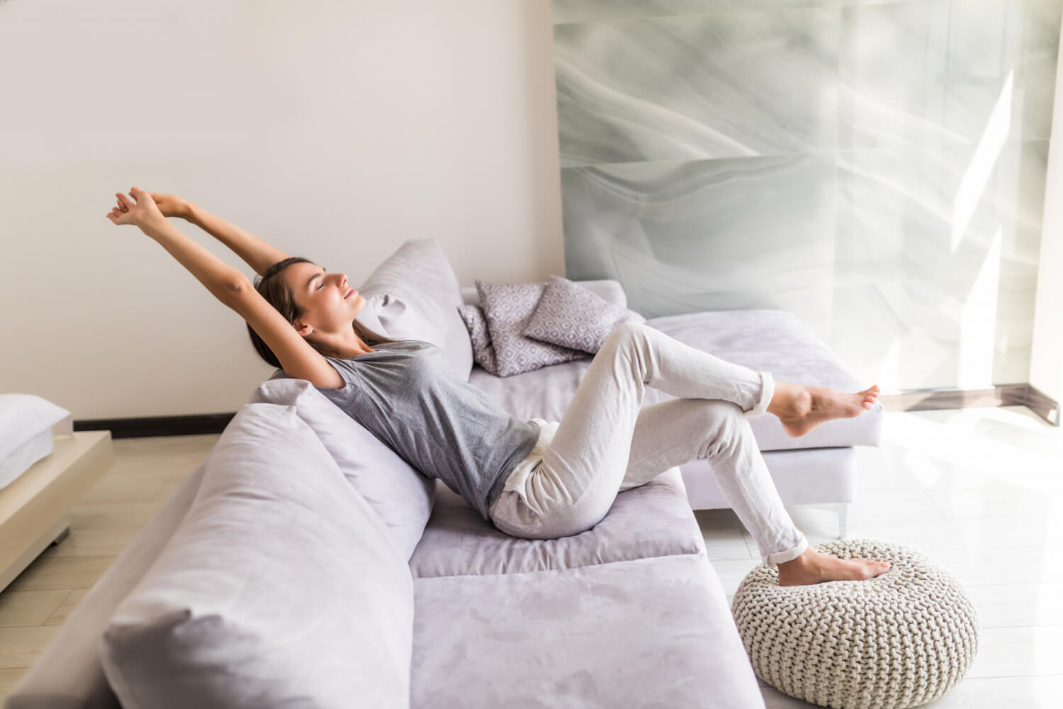 Smiling young woman relax lying couch staycation